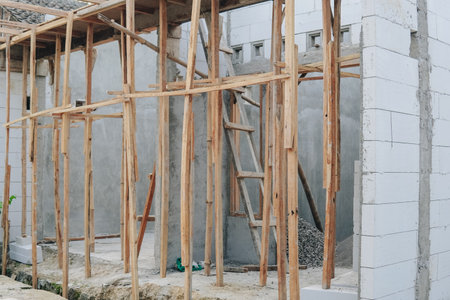 A construction site with a ladder leaning against a wall, unfinished house or building.の写真素材