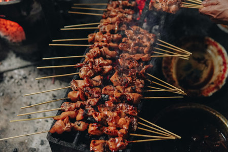 The process of making Indonesian chicken satay in traditional way using charcoal, tasty Asian...