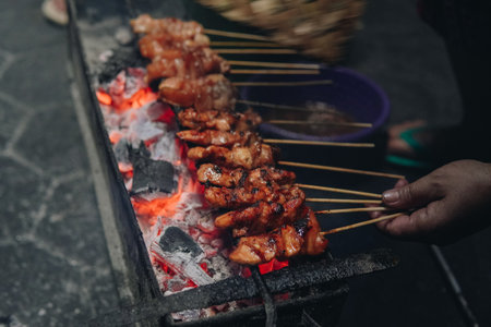 The process of making Indonesian chicken satay in traditional way using charcoal, tasty Asian cuisine.の写真素材