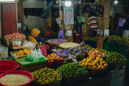 Portrait of an Indonesian fruits market with full of fresh product, including oranges, apples, and bananas. The atmosphere is lively and bustling.の写真素材