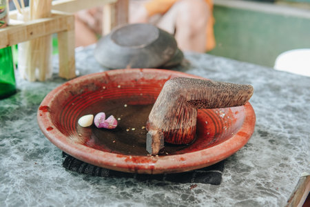 Traditional tool called ulekan with onion and garlic on it to make sambal bawang, a delicious traditional sauce from Indonesia.の写真素材