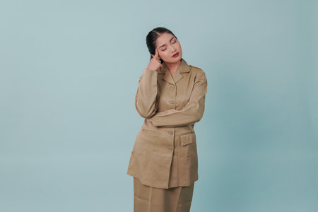 Serious Indonesian government worker woman doing thinking gestures while looking upward.の写真素材