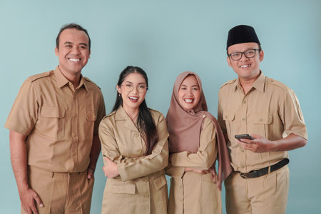 Four Indonesian government workers in khaki uniform posing and smiling to the camera. PNS and civil servant concept.の写真素材