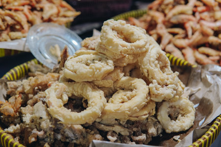 A basket of fried calamari snack being sold in a traditional market.