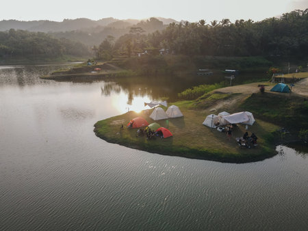 Aerial morning view of camping ground area by the Sermo Lake with forest hill on the background in Kulonprogo, Yogyakarta, Indonesia.の写真素材
