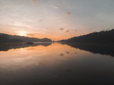 Aerial view of sunset on Sermo lake, Yogyakarta, Indonesia, with sun reflections over the clear water.の写真素材