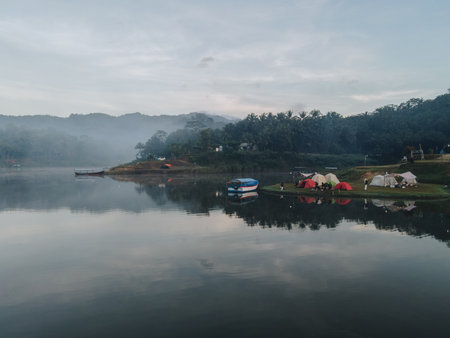 Nature photography of clear water lake with boats in a foggy morning and camping ground at Sermo lake, Kulonprogo, Yogyakarta, Indonesia.の写真素材