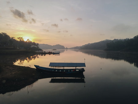 Nature photography of beautiful clear water lake with fisherman's boats in a foggy morning and camping ground at Sermo lake, Kulonprogo, Yogyakarta, Indonesia.の写真素材
