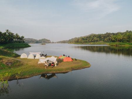 Aerial morning view of camping ground area by the Sermo Lake with forest hill on the background in Kulonprogo, Yogyakarta, Indonesia.の写真素材