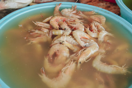 A basket of fresh shrimp being sold in the fish market.