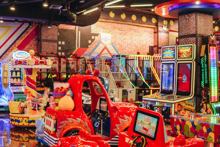 The interior of an arcade game center in an Indonesian mall, filled with various game machines and rides.の写真素材