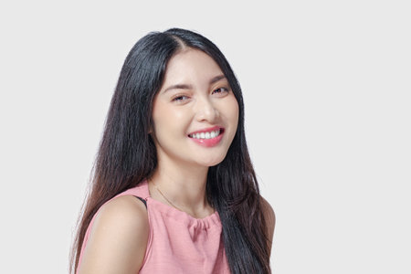 Excited young Asian woman wearing pink dress with a joyful expression, isolated by white background.の写真素材