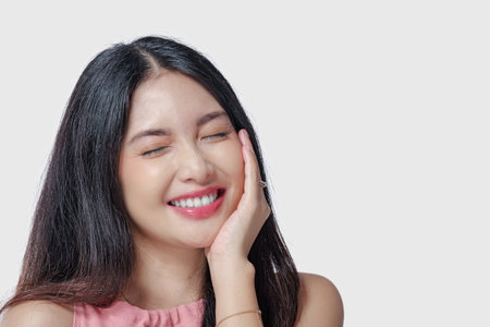 Excited young Asian woman wearing pink dress with a joyful expression, isolated by white background.の写真素材
