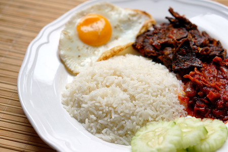 Nasi lemak (coconut rice) served with sunny side up egg, hot spicy fried beef lungs and hot spicy sauce. Nasi lemak is a fragrant rice dish cooked in coconut milkの写真素材