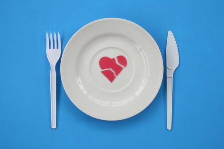 On a plate the broken off silhouette of heart lays.の写真素材