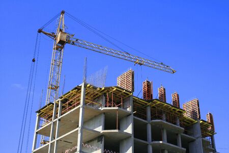 The image of construction of a building and the tower crane.