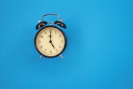 The image of an alarm clock on a blue background.の写真素材