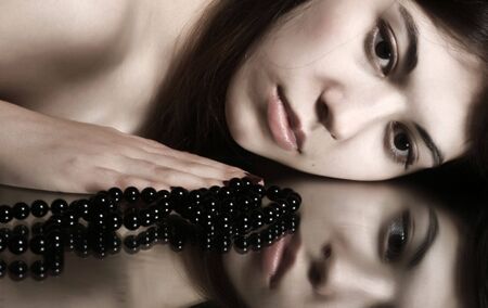 Portrait of the young brunette on a black background.の写真素材