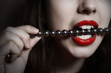 Red lips and beads in a teeth.の写真素材