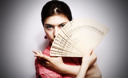 Portrait of the girl in pink to a blouse and a fan in a hand.の写真素材