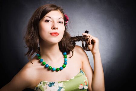 The attractive young brunette on a dark background. の写真素材