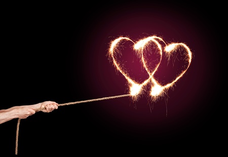 Sparkling Love Heart pulls a pair of hands at the rope.の写真素材