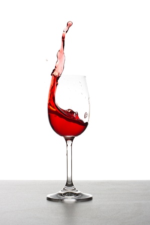 Red wine splashing from glass, isolated on white backgroundの写真素材