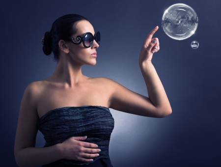 Woman in sunglasses and soap bubbles の写真素材