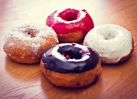 Colorful donuts on a wooden surface の写真素材