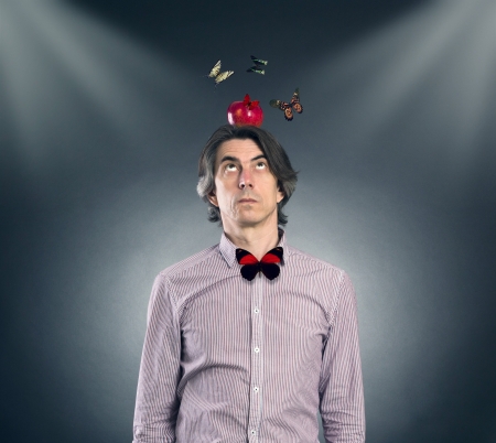 A man with an apple on his head and flying butterflies の写真素材