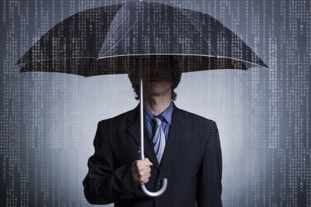 Businessman with an umbrella under digital rain の写真素材