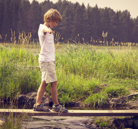 Boy on a wooden bridgeの写真素材