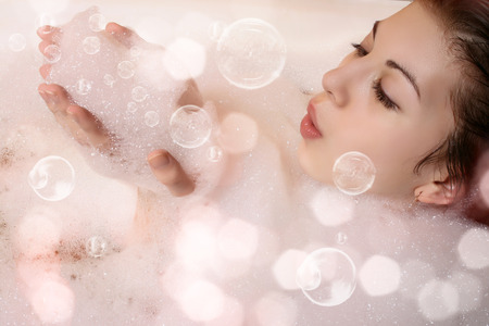 Beautiful woman in bathroom. Female in bath with foam