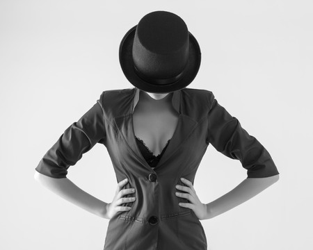 Beautiful young woman in a black hat and jacket with an open neckline.の写真素材