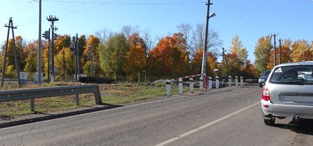 Cars on railway crossing on a sunny autumn dayの写真素材