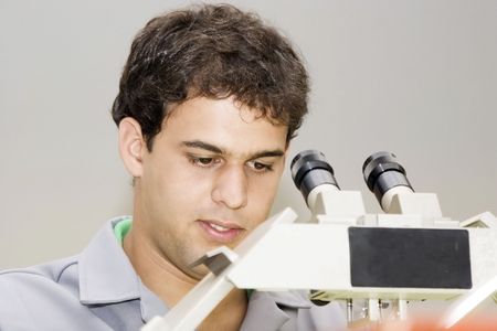 Medical  professional looking through a microscopeの写真素材