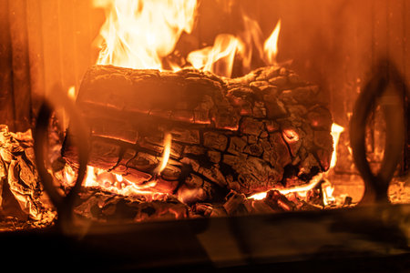 Log of wood burning in a fireplace inside a house, hearth