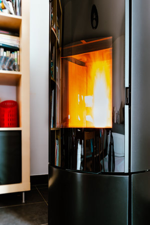 Pellet stove burning with flame in a living room with bookcaseの写真素材