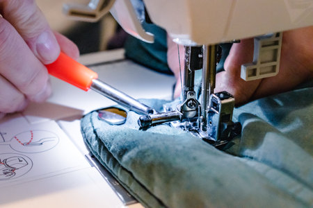 Person using a sewing machine with a garment, for repair work, customization, creation, upcycling