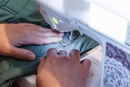 Person using a sewing machine with a garment, for repair work, customization, creation, upcycling