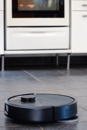 Robot vacuum cleaner with dust, real life photo, saves time and goes into hard-to-reach placesの写真素材