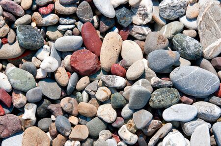Texture of stone pebbles mainly marble, granite and slate on a beach