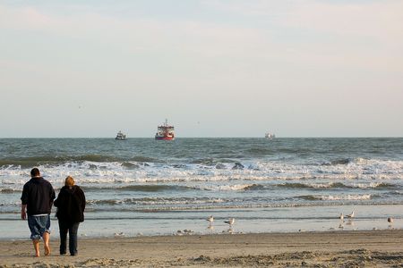 Couple walks together on the beachの写真素材