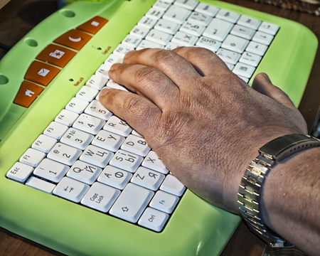 Close up of old male hand on keyboard of laptopの写真素材