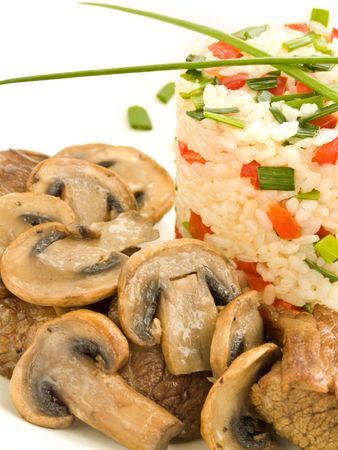 Dinner plate with rice, fried meat, mushrooms and fresh vegetables. Shallow dof.の写真素材