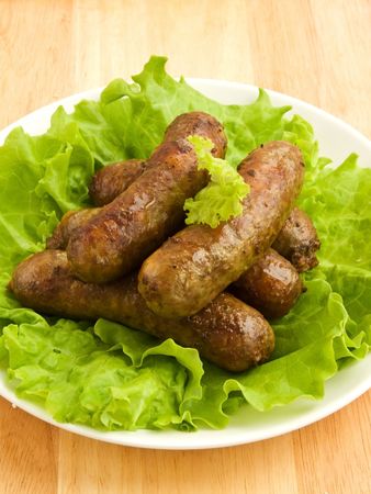 Plate with grilled sausages and salad leaves. Shallow dof.の写真素材
