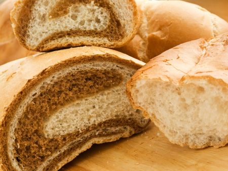 Fresh bread loafs on wooden background. Shallow dof.