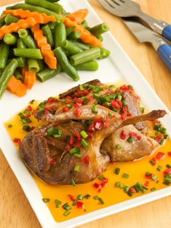Dinner plate with roasted quails in saffron sauce and vegetable garnish. Shallow dof.の写真素材