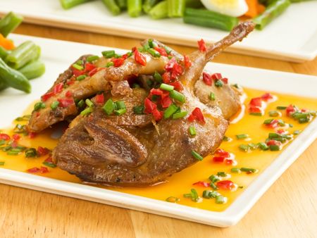 Dinner plate with roasted quails in saffron sauce and vegetable garnish. Shallow dof.の写真素材