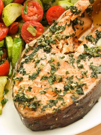 Plate with baked salmon steak and warm vegetable salad. Shallow dof.の写真素材